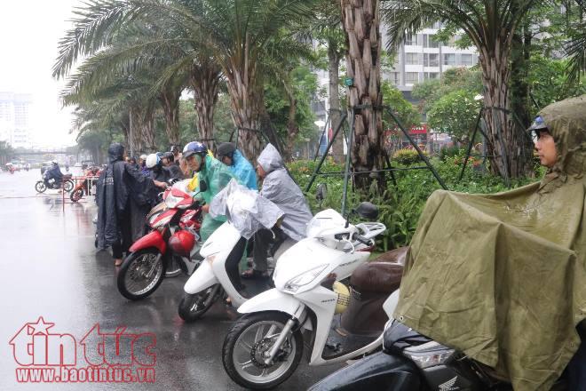 Phụ huynh đứng dưới mưa tầm tã đợi con ảnh 1